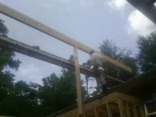 Carpenter setting a ridge beam over a new addition frame — Ice Dam Removal by Roofing Brothers in Foresthill
