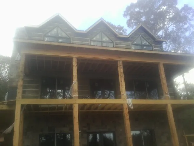 Dormers and porch framing on a large log home under construction — Roof Coating work by our crew in Foresthill