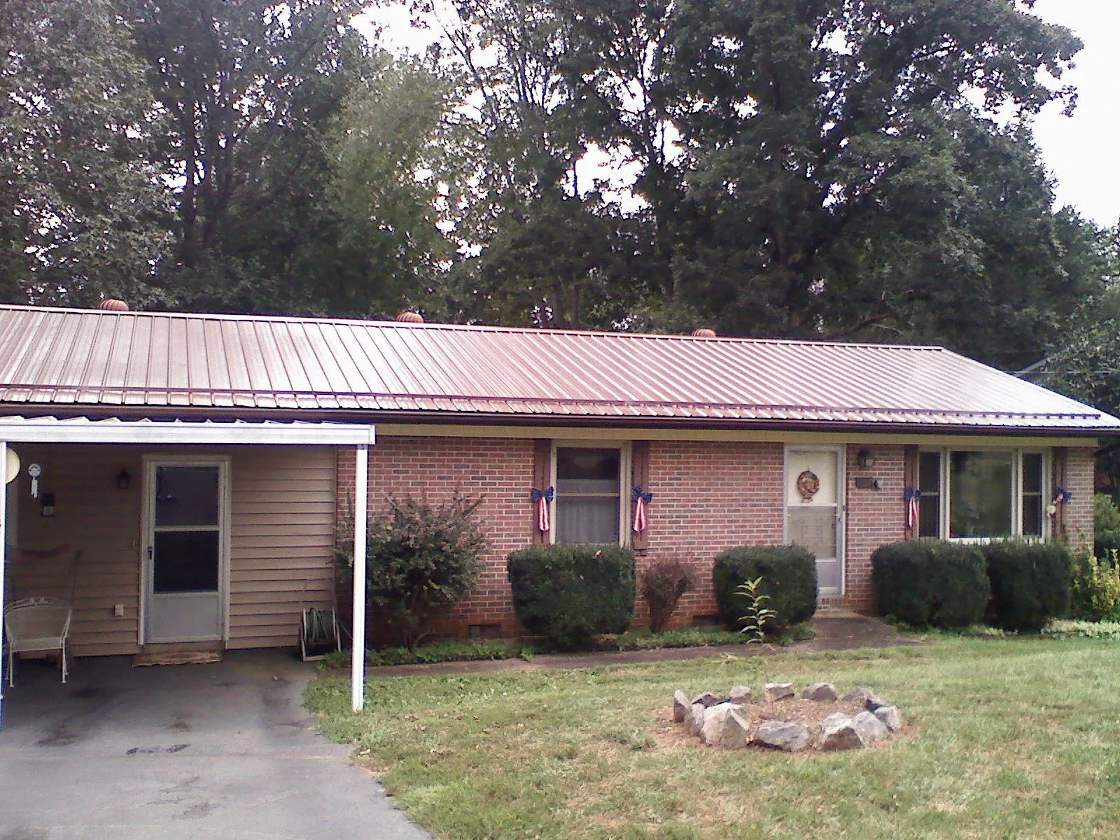 Bronze metal roof and carport on a brick ranch home — Roof Repair work by our crew in Foresthill